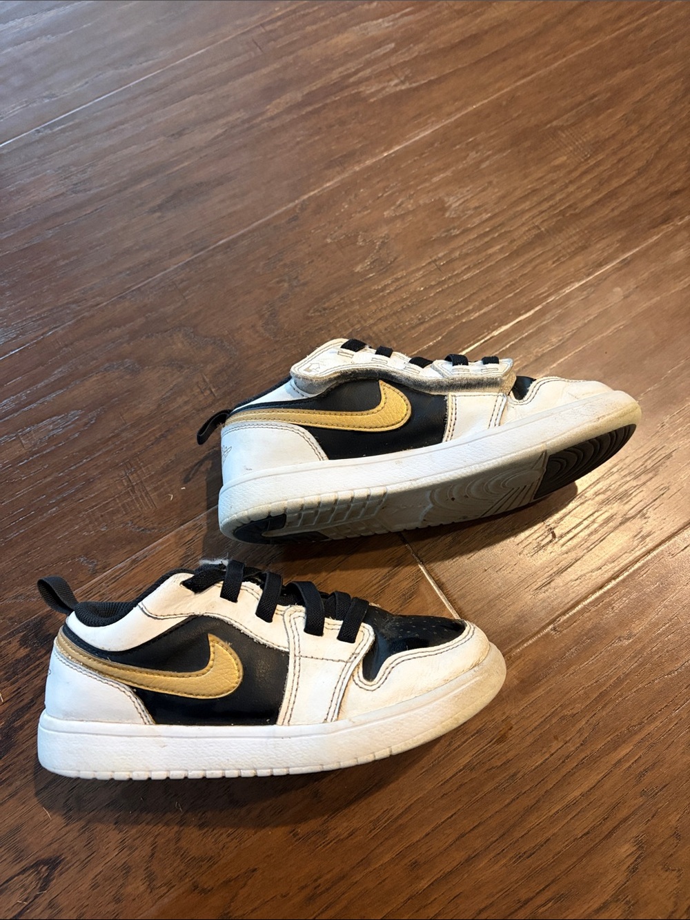 Nike Kids Low-Top Sneakers in Black, White & Gold Swoosh